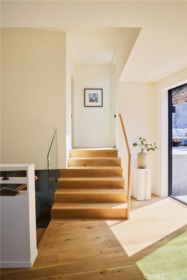 stairs featuring hardwood / wood-style floors