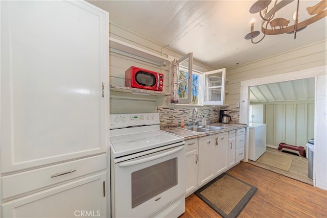 kitchen featuring sink, electric range, white cabinets, light hardwood / wood-style floors, and wood walls