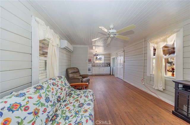 interior space with ceiling fan, wood walls, dark wood-type flooring, and a wall mounted AC