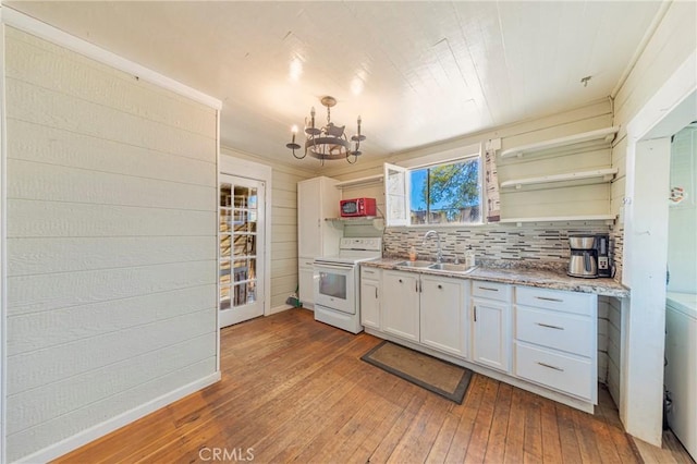 kitchen with sink, a notable chandelier, white range with electric cooktop, white cabinets, and light wood-type flooring