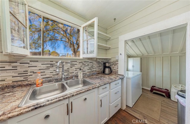 kitchen with wooden walls, sink, white refrigerator, white cabinets, and dark hardwood / wood-style floors