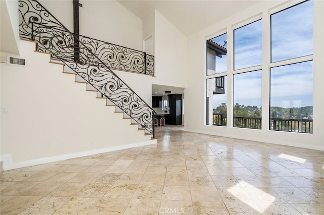 foyer entrance with a high ceiling, stairway, visible vents, and baseboards