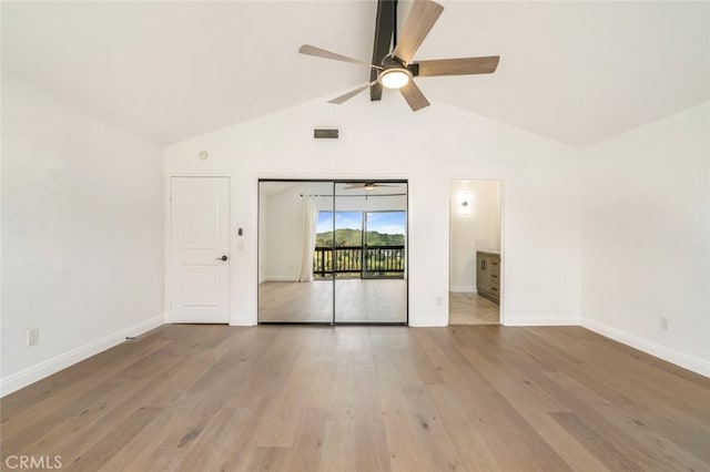 spare room featuring visible vents, a ceiling fan, wood finished floors, high vaulted ceiling, and baseboards