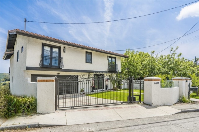 mediterranean / spanish house with a fenced front yard, a gate, and stucco siding