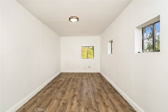 unfurnished room featuring baseboards and wood finished floors