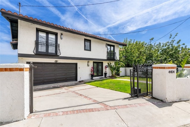 view of front of house featuring a fenced front yard, an attached garage, concrete driveway, a gate, and stucco siding