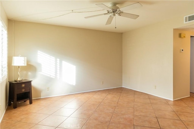 spare room with ceiling fan and light tile patterned flooring