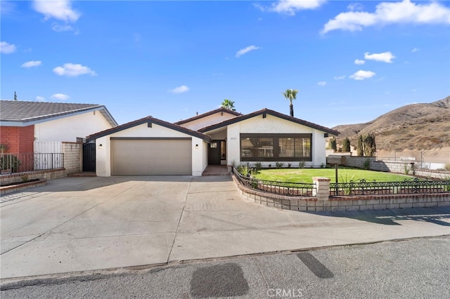 single story home featuring a mountain view, a garage, and a front yard