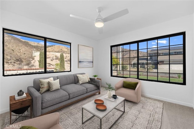 carpeted living room with ceiling fan, plenty of natural light, and a mountain view