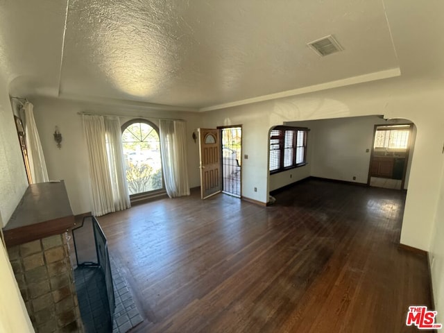 interior space featuring a textured ceiling and dark hardwood / wood-style floors