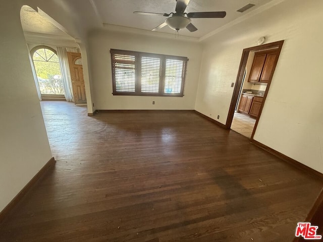 unfurnished room with crown molding, dark hardwood / wood-style floors, and ceiling fan