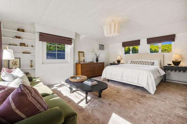 carpeted bedroom featuring a wall mounted air conditioner and multiple windows