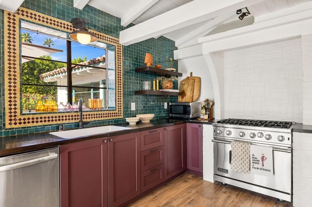 kitchen with appliances with stainless steel finishes, light wood-type flooring, tasteful backsplash, sink, and vaulted ceiling with beams