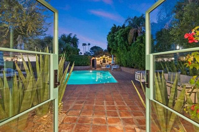 pool at dusk with a patio