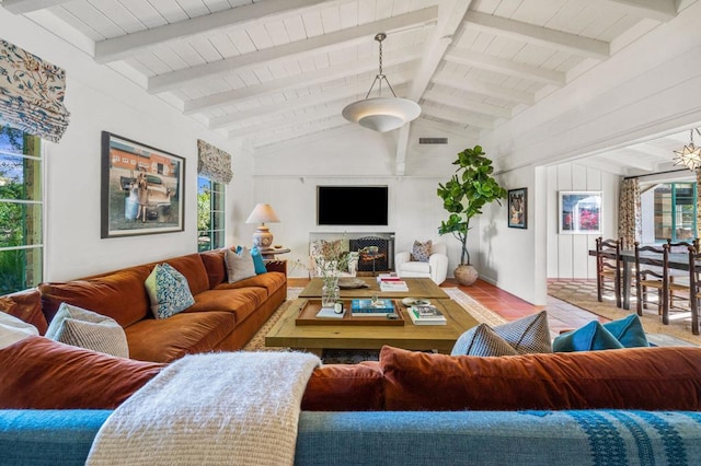 living room with vaulted ceiling with beams, light tile patterned floors, and a wealth of natural light