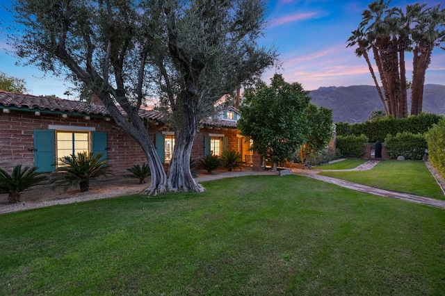 view of front of house featuring a mountain view and a yard