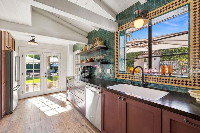 kitchen featuring decorative backsplash, appliances with stainless steel finishes, french doors, sink, and light hardwood / wood-style flooring