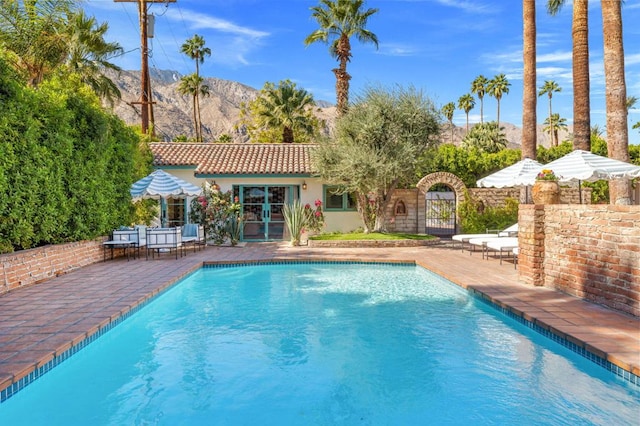 view of swimming pool featuring a mountain view and a patio