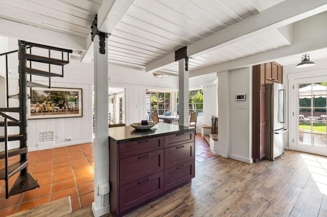 kitchen with hardwood / wood-style flooring, plenty of natural light, stainless steel fridge, and beamed ceiling