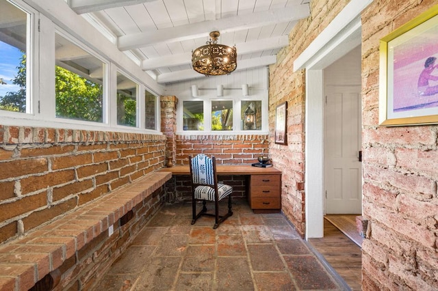 office with beam ceiling, dark hardwood / wood-style flooring, and brick wall