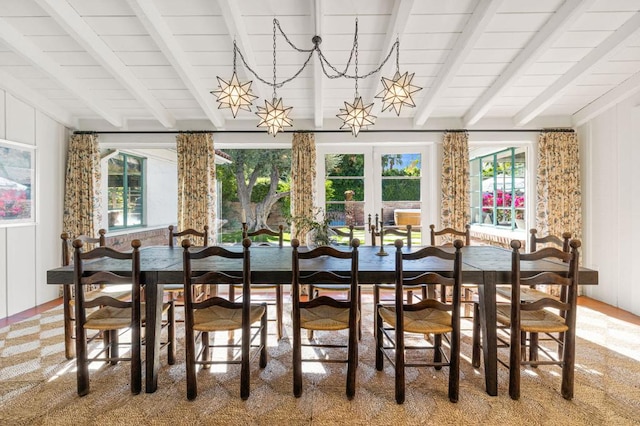 dining room featuring french doors, plenty of natural light, and beam ceiling