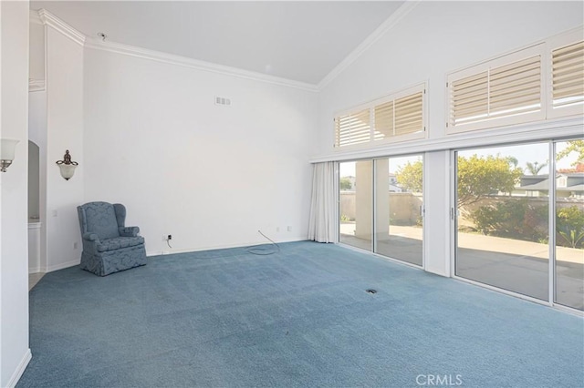 carpeted empty room with ornamental molding, high vaulted ceiling, and a healthy amount of sunlight