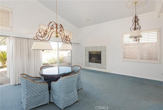 carpeted dining space with a tiled fireplace, high vaulted ceiling, and ornamental molding