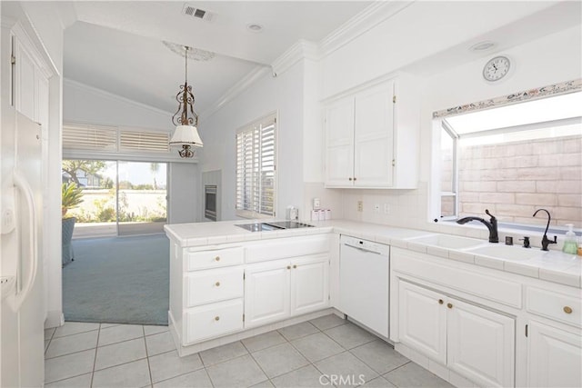 kitchen with sink, tile countertops, white appliances, light carpet, and white cabinets