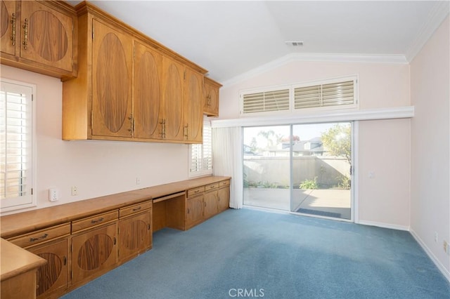 kitchen featuring light carpet, built in desk, vaulted ceiling, and crown molding