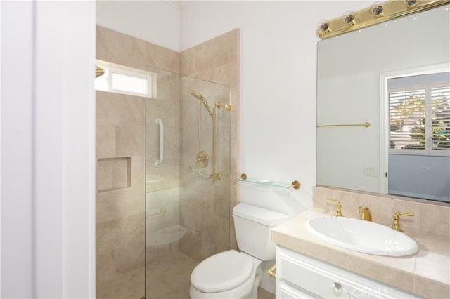 bathroom featuring vanity, a shower with shower door, and toilet