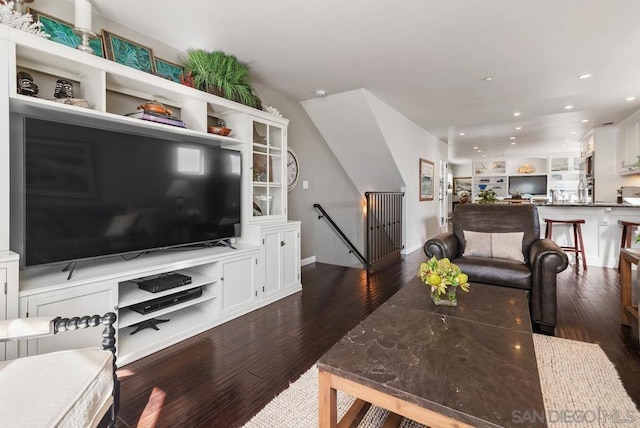 living room with built in shelves and dark hardwood / wood-style flooring