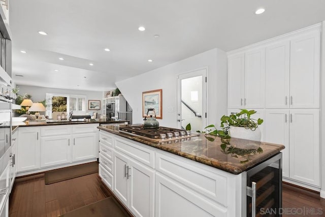 kitchen featuring dark stone counters, white cabinetry, stainless steel gas cooktop, and wine cooler