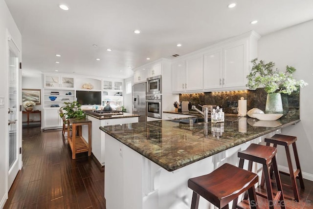 kitchen featuring sink, stainless steel appliances, white cabinetry, and a kitchen island