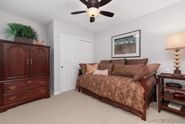 bedroom featuring ceiling fan, a closet, and light carpet