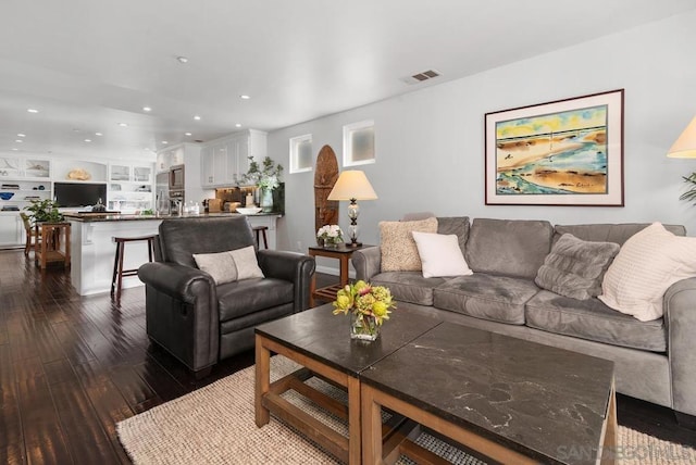 living room featuring dark hardwood / wood-style flooring and built in features