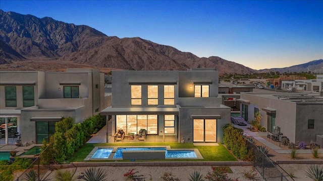 back of property with a mountain view and a patio