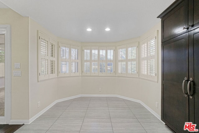 tiled empty room featuring plenty of natural light