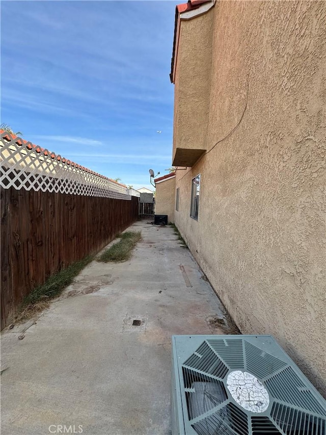 view of side of property featuring cooling unit and a patio