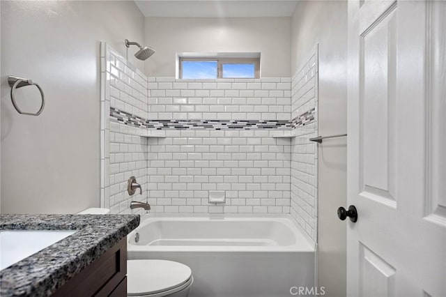 full bathroom with tiled shower / bath, vanity, and toilet