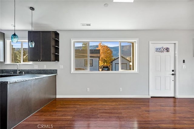 kitchen featuring dark brown cabinets, dark hardwood / wood-style floors, pendant lighting, and sink