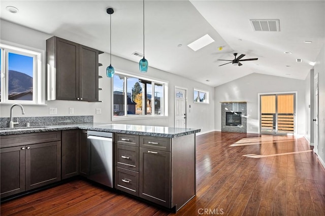 kitchen featuring dark hardwood / wood-style floors, decorative light fixtures, dishwasher, sink, and dark stone counters