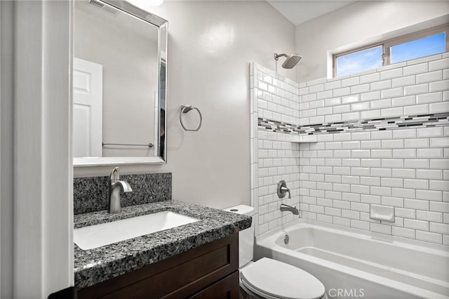 full bathroom with tiled shower / bath, vanity, and toilet