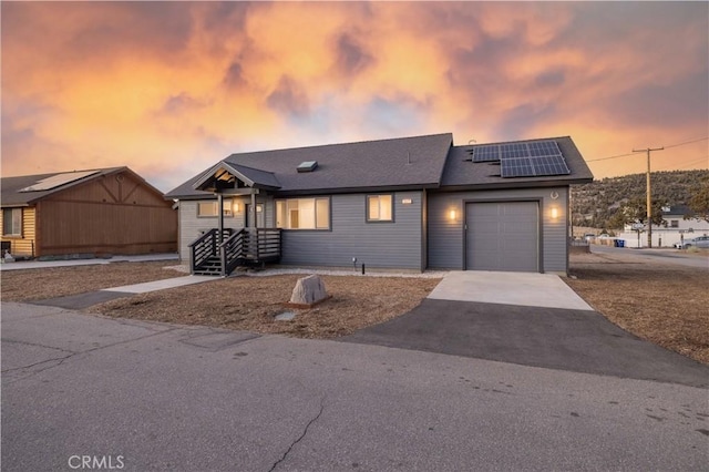 view of front facade featuring a garage and solar panels