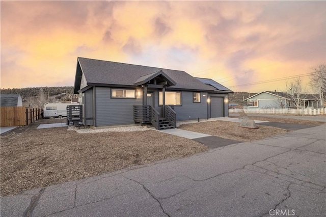 view of front of property featuring a garage and solar panels