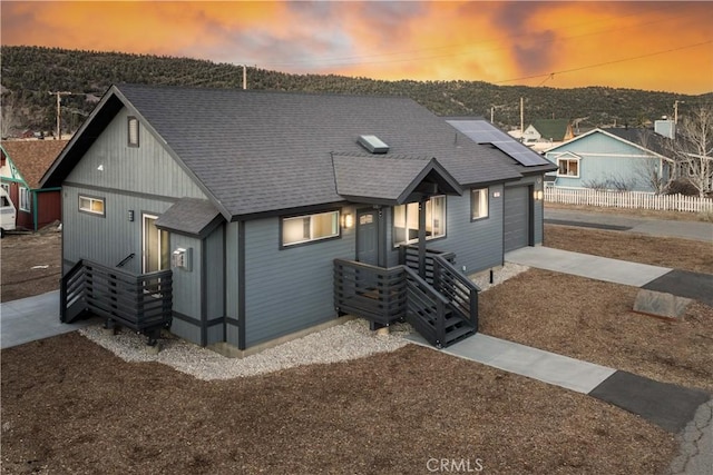 view of front facade with a garage and solar panels