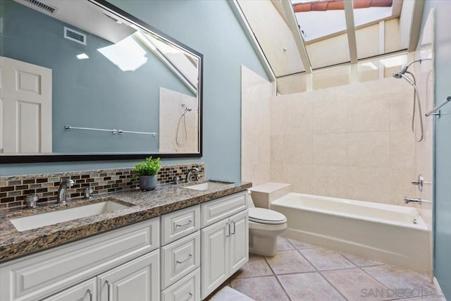 full bathroom with tasteful backsplash, tile patterned floors, vanity, toilet, and tiled shower / bath