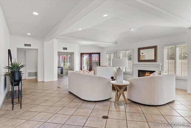 living room featuring lofted ceiling with beams, light tile patterned floors, and french doors