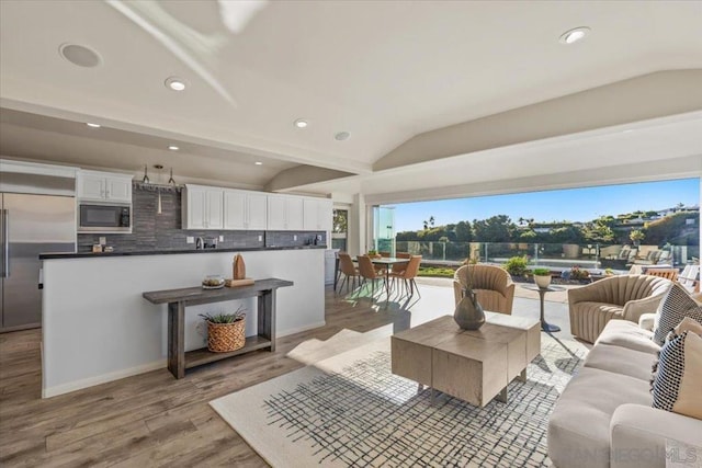 living room featuring light hardwood / wood-style flooring and vaulted ceiling