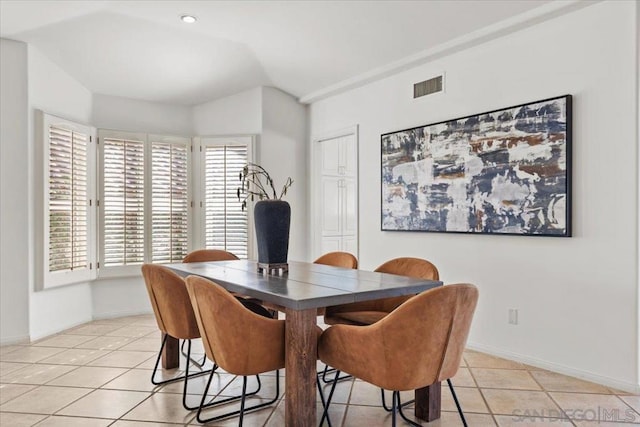 dining space featuring lofted ceiling and light tile patterned flooring