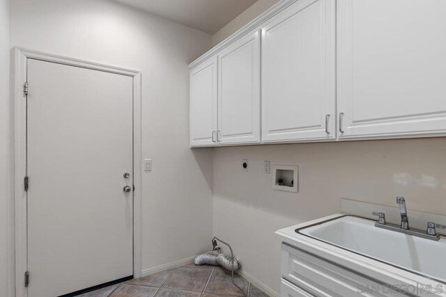 laundry area featuring sink, cabinets, hookup for an electric dryer, hookup for a washing machine, and light tile patterned floors